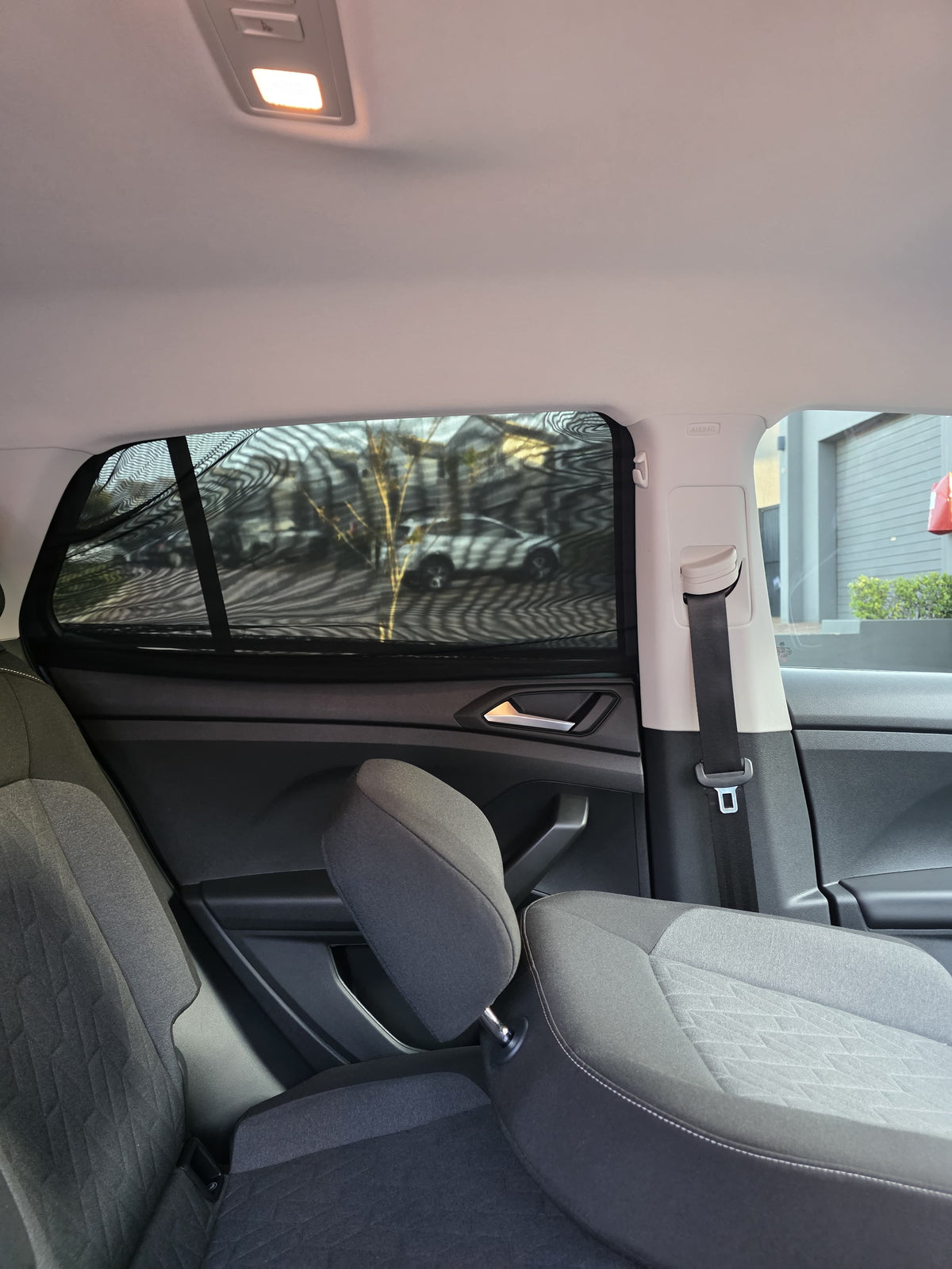 Sun shade sock fitted to a rear side window, viewed from inside the car